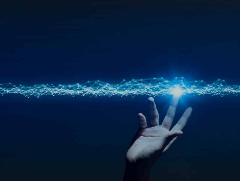 Hand touching a blue light beam of interconnected wires